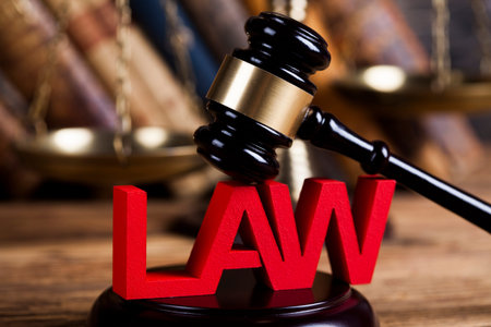 Law theme, mallet of the judge, justice scale, wooden desk background