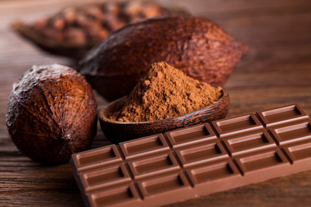 Aromatic cocoa and chocolate on wooden background