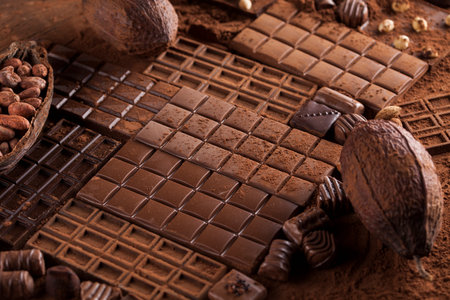 Dark homemade chocolate bars and cocoa pod on wooden