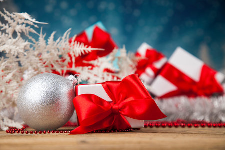 Christmas presents with red ribbon on woodenの写真素材