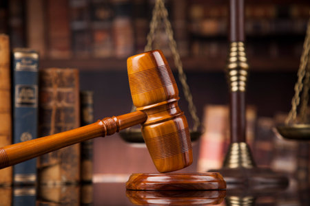 Law theme, mallet of the judge, wooden desk, books