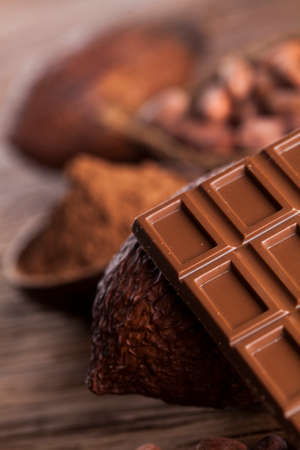 Dark homemade chocolate and cocoa pod on woodenの写真素材