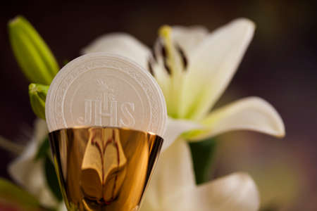 Holy communion a golden chalice with grapes and bread wafersの写真素材