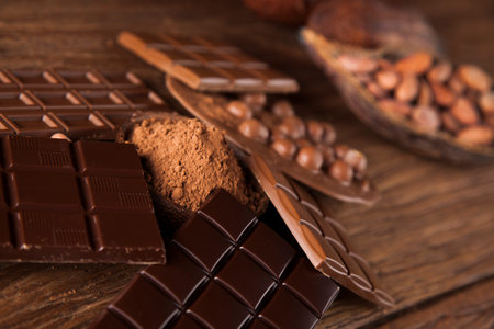 Aromatic cocoa and chocolate on wooden background