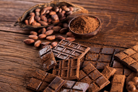 Dark homemade chocolate bars and cocoa pod on wooden