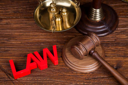Law theme, mallet of the judge, justice scale, wooden desk backgroundの写真素材