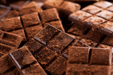 Dark homemade chocolate bars and cocoa pod on wooden