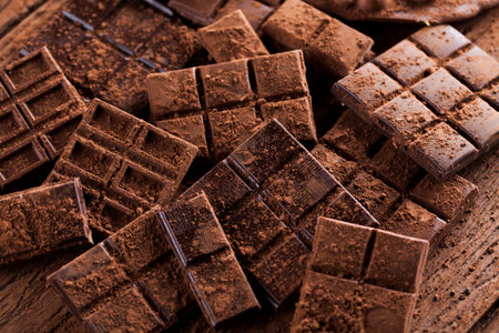 Dark homemade chocolate bars and cocoa pod on wooden