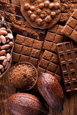 Dark homemade chocolate bars and cocoa pod on wooden