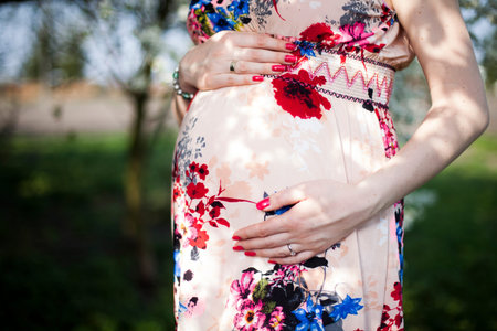Young beautiful pregnant woman, blooming gardenの写真素材