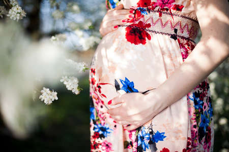 Beautiful pregnant woman relaxing outside in the Orchardの写真素材