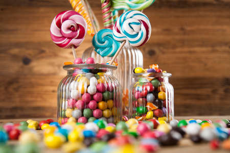 Glass jars in Colorful candies,lollipops and gum ballsの写真素材