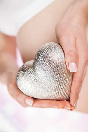 Pregnant woman holding a heartの写真素材