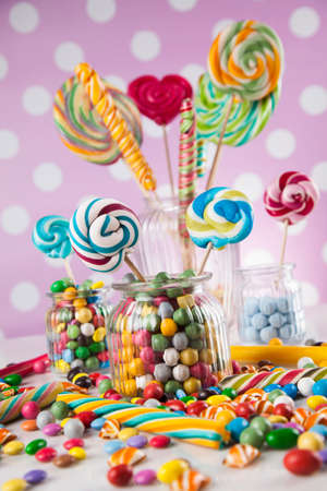 Glass jars in Colorful candies, lollipops and gum ballsの写真素材
