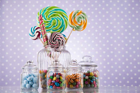 Glass jars in Colorful candies,lollipops and gum ballsの写真素材