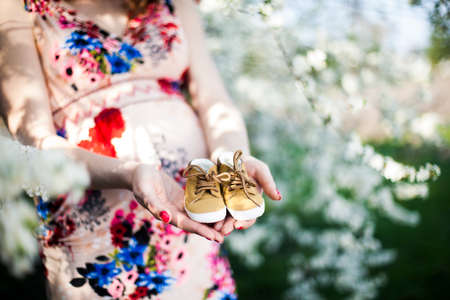 Beautiful pregnant woman relaxing outside in the Orchardの写真素材