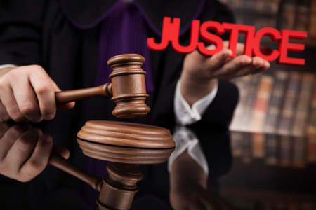 Judge, male judge in a courtroom striking the gavelの写真素材