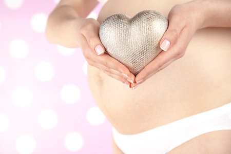 Pregnant woman holding a heart