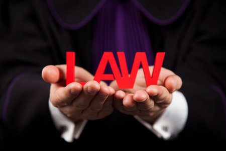 male judge in a courtroom hand holding lawの写真素材