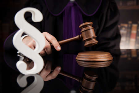 Male judge in a courtroom striking the gavelの写真素材