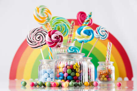 Glass jars in Colorful candies,lollipops and gum ballsの写真素材