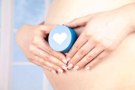 Pregnant woman holding a heartの写真素材