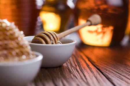 Honey in the comb, glass jar on wooden backgroundの写真素材