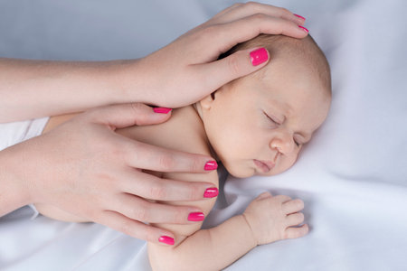 Newborn baby hand holding mother