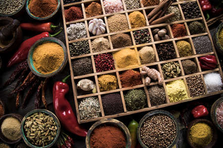 Variety of wooden box, spices and herbs on kitchen tableの写真素材