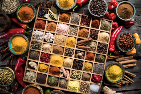 Variety of wooden box, spices and herbs on kitchen tableの写真素材