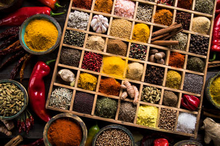 Variety of wooden box, spices and herbs on kitchen tableの写真素材