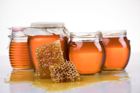 Sweet honey in the comb, glass jar on wooden background