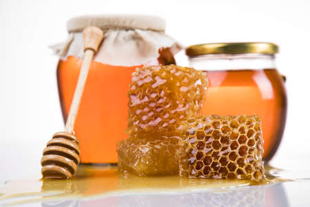 Sweet honey in the comb, glass jar on wooden backgroundの写真素材