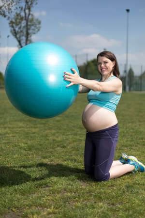 Pregnant woman excercises with gymnastic ballの写真素材