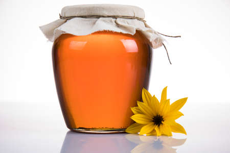 Sweet honey in the comb, glass jar on wooden backgroundの写真素材