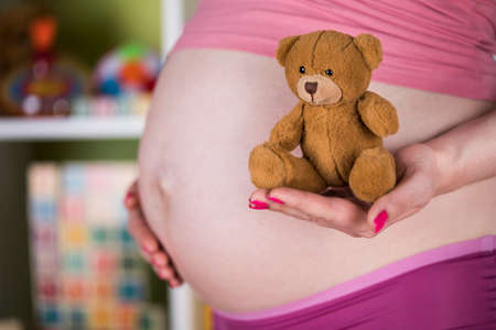Teddy bear toy, pregnant womanの写真素材