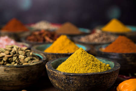 Wooden table of colorful spicesの写真素材