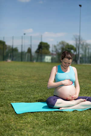 Healthy pregnant woman doing yoga in natureの写真素材