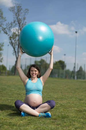 Pregnant woman excercises with gymnastic ballの写真素材