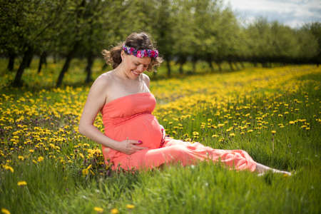 Meadow, Spring, Young beautiful pregnant womanの写真素材