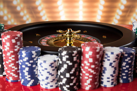 Poker Chips on gaming table, roulette wheel in motion, casino background