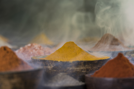 Assorted Spices and wooden bowl of smokeの写真素材
