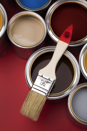 Full Buckets of rainbow colored oil paint on red backgroundの写真素材