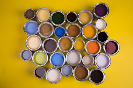 Full Buckets of rainbow colored oil paint on red backgroundの写真素材