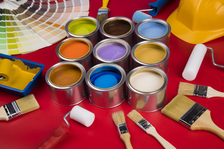 Full Buckets of rainbow colored oil paint on red backgroundの写真素材