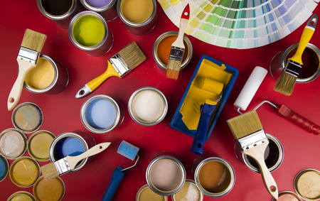 Full Buckets of rainbow colored oil paint on red backgroundの写真素材