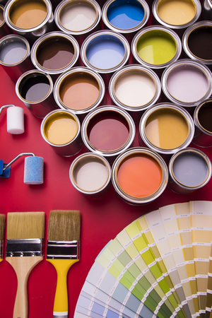Buckets full of rainbow colored oil paint, red backgroundの写真素材