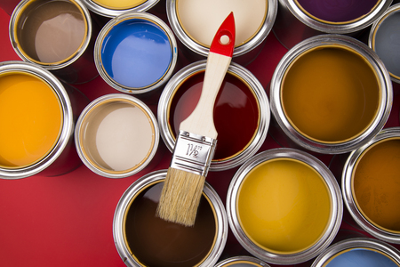 Open buckets with a paint and brush, red backgroundの写真素材
