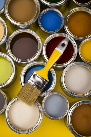Paint can and paintbrush, yellow backgroundの写真素材
