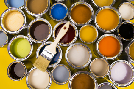 Can with paint and paintbrush, yellow backgroundの写真素材